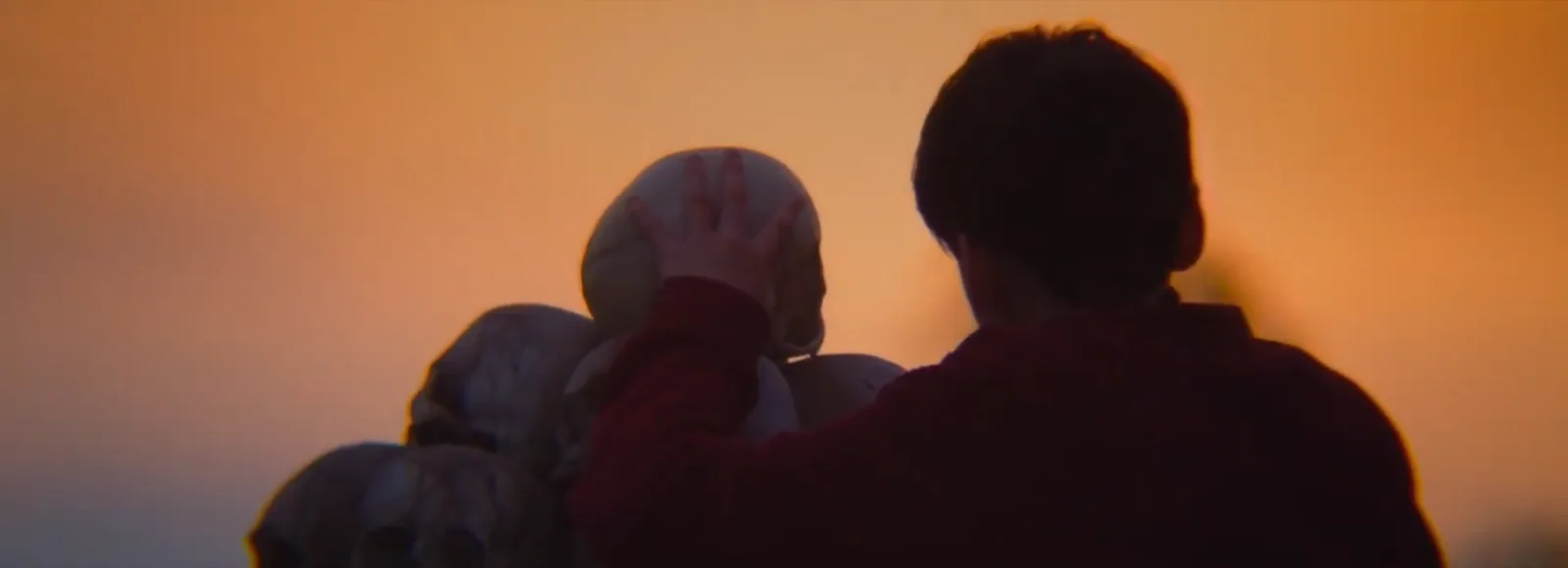 Spike silhouetted against a sunrise as he places his mother's skull atop the central pillar of the bone temple